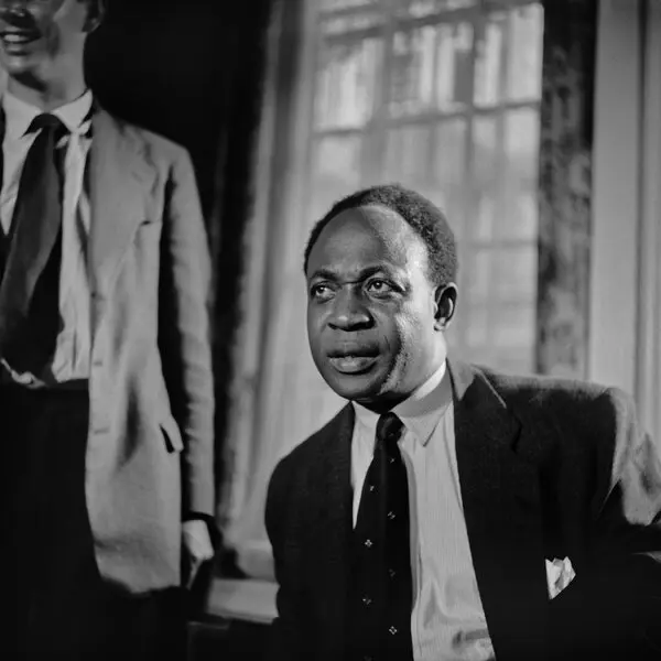 Kwame Nkrumah at an Official Engagement Kwame Nkrumah seated indoors during an official occasion, with part of another man visible at the edge of the photograph.